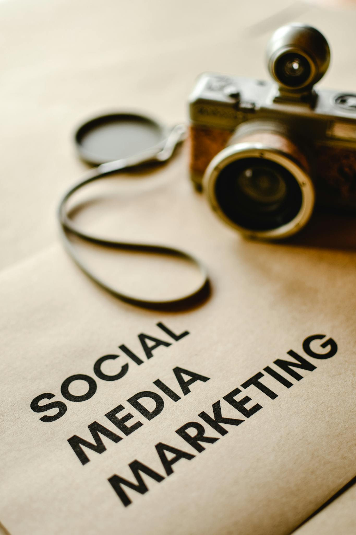 Close-up of a vintage camera on brown paper labeled with 'Social Marketing'.