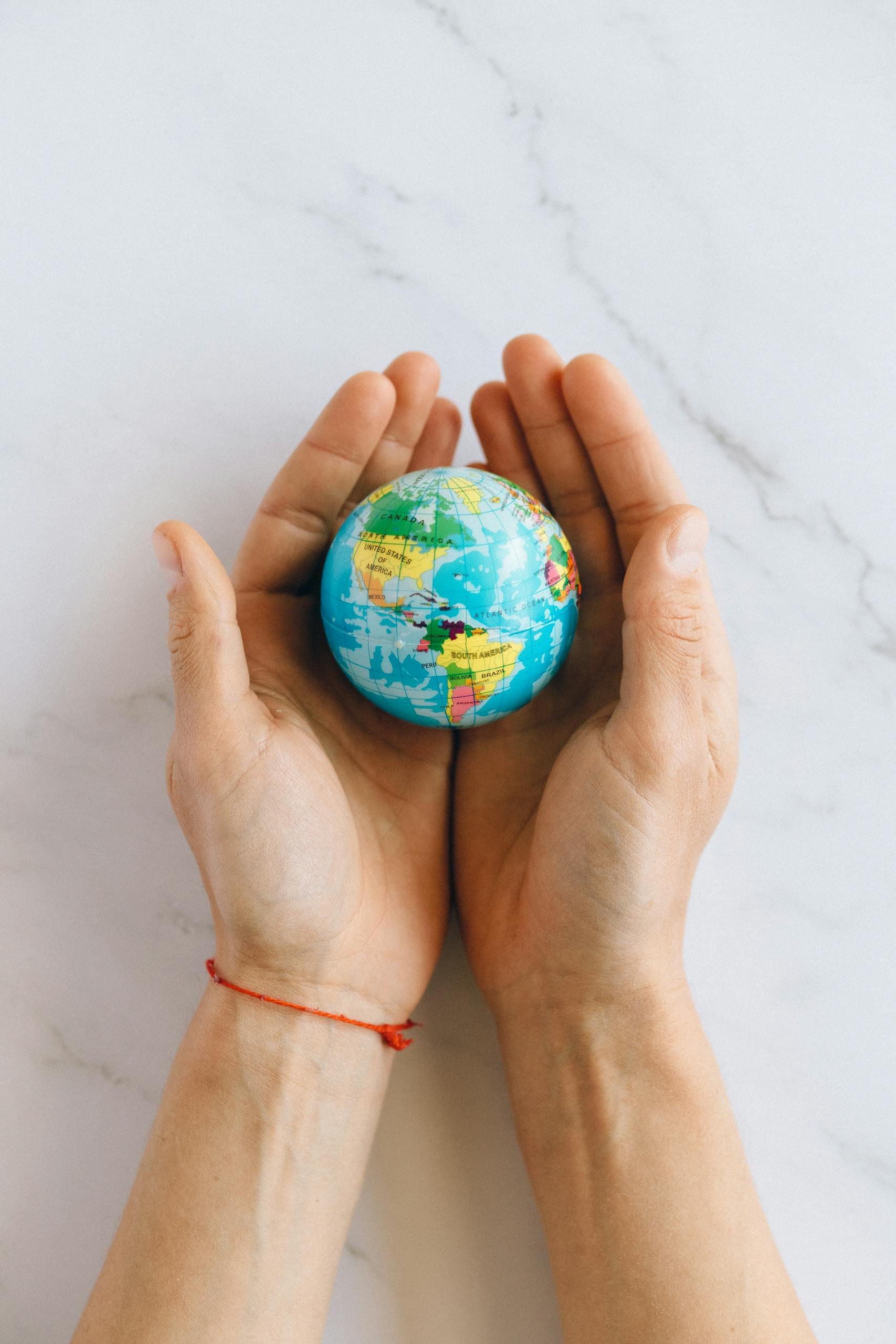 strategie di web marketing - immagine di due mani che reggono un piccolo mappamondo